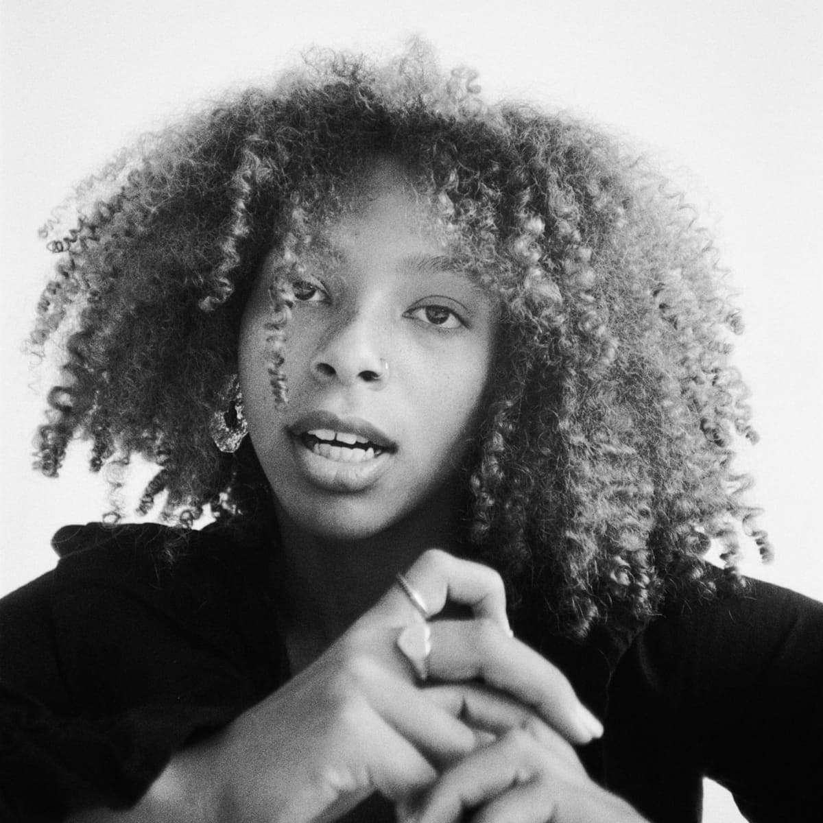 A black-and-white studio portrait of a client with a full natural afro.