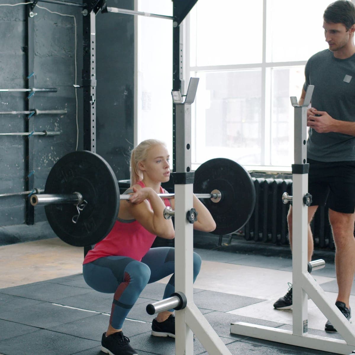 A client working through a front squat at the rack.