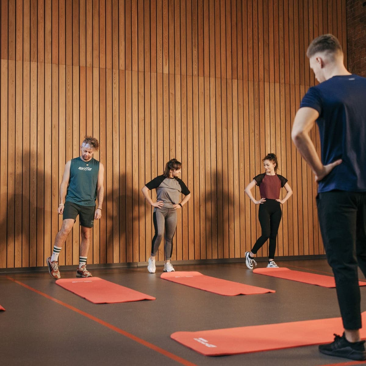 A small group class spread out on mats in the studio.